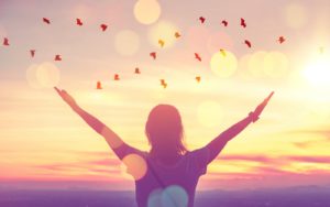 Silueta de una persona con los brazos abiertos al amanecer, sobre qué es el mindfulness y cómo se practica