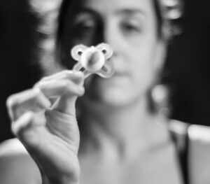 Imagen en blanco y negro de una mano tensa, sobre el arrepentimiento de ser madre y el malestar en la maternidad
