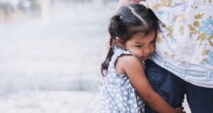 Niña pequeña abrazándose con fuerza a su madre, imagen sobre la ansiedad por separación infantil