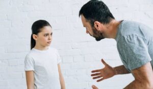 Padre e hija adolescente enfrentados con gesto serio, sobre cómo conseguir que los hijos obedezcan